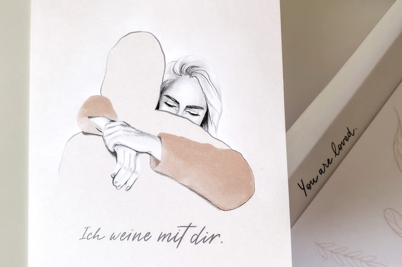 Grußkarte mit einer gezeichneten Umarmung und dem Satz „Ich weine mit dir."