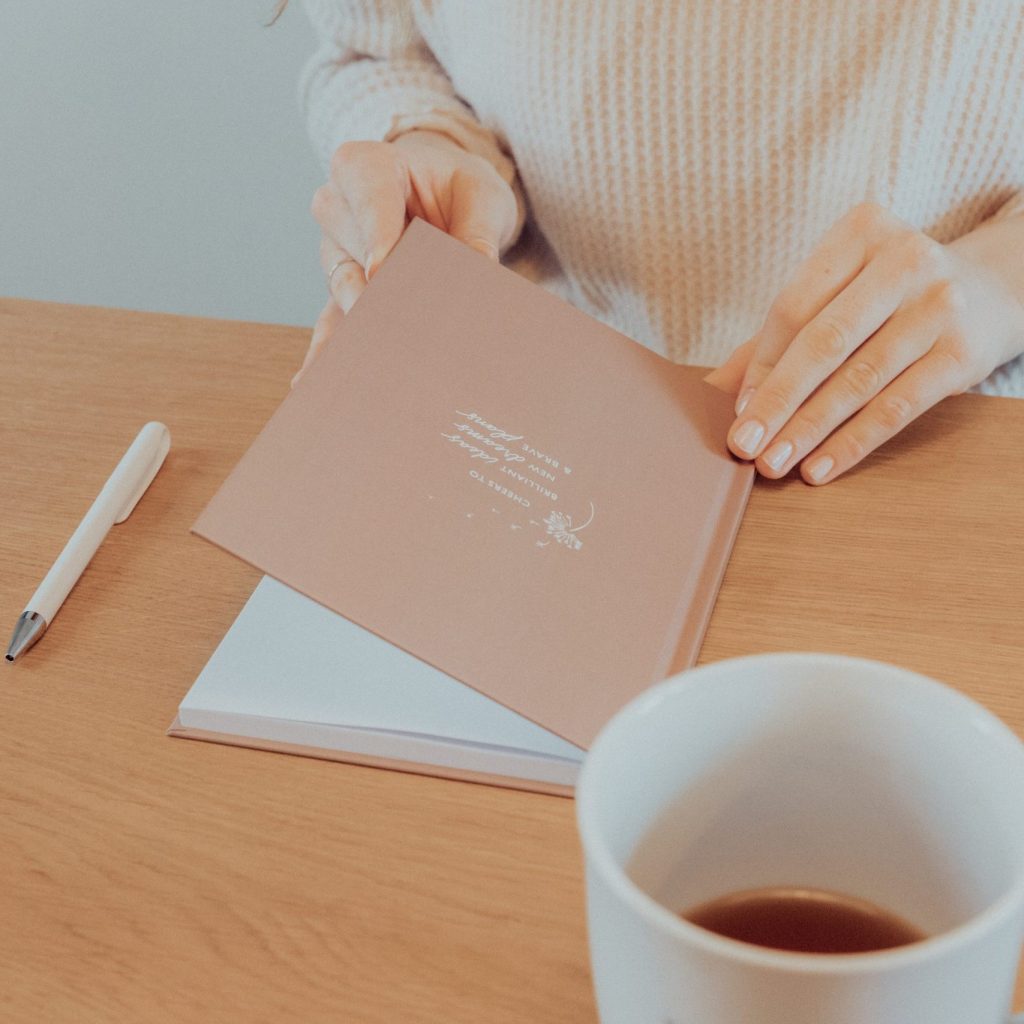 Notizbuch, Stift und Kaffeetasse auf einem Schreibtisch
