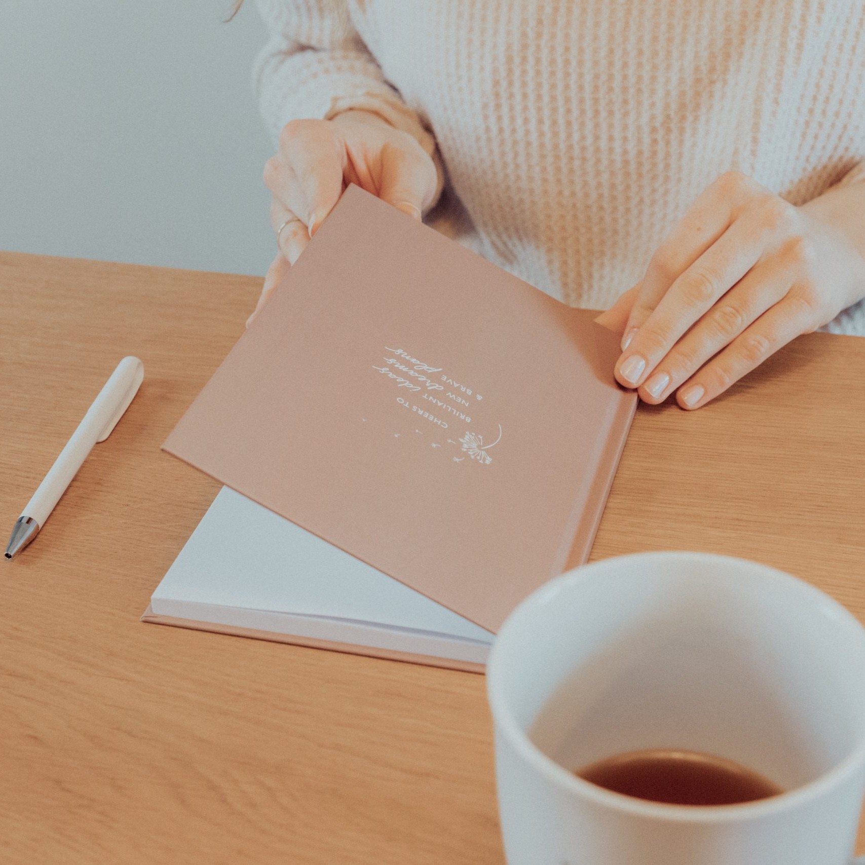 Notizbuch, Stift und Kaffeetasse auf einem Schreibtisch